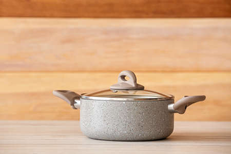 Cooking pot on table against wooden backgroundの写真素材