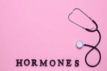 Word HORMONES and stethoscope on color backgroundの写真素材