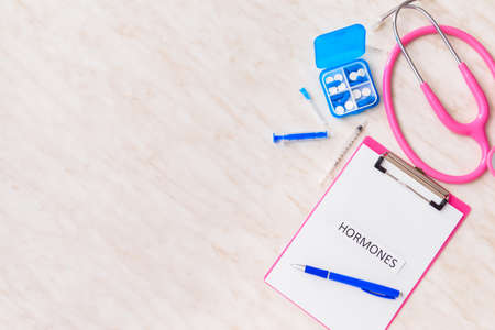 Clipboard with word HORMONES, stethoscope, syringes and pills on white backgroundの写真素材