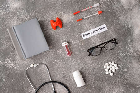 Word ENDOCRINOLOGY, thyroid gland, syringes, stethoscope and pills on gray backgroundの写真素材