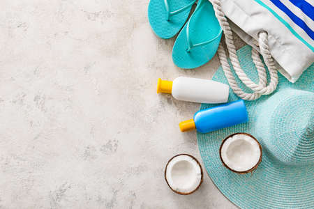 Beach bag with sunscreen cream and accessories on white background