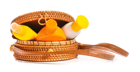 Beach bag with sunscreen cream on white background
