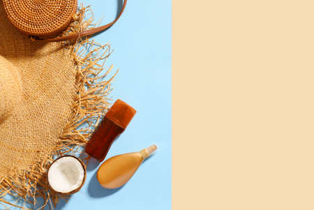 Beach bag with sunscreen cream and hat on color backgroundの写真素材