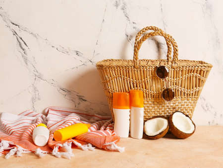 Beach bag with sunscreen cream and accessories on tableの写真素材