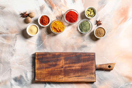 Wooden cutting board with spices on light backgroundの写真素材