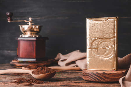 Pack with coffee, spoons and grinder on wooden tableの写真素材