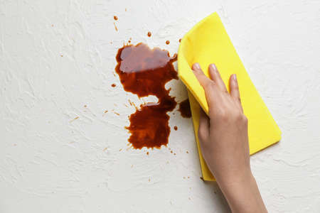 Woman cleaning fresh coffee stainsの写真素材