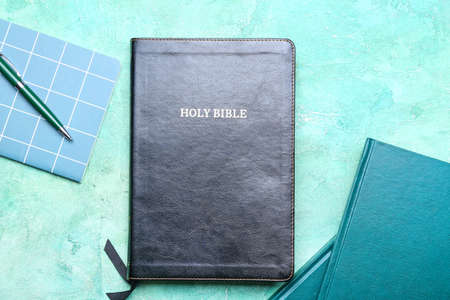 Holy Bible in workplace on color backgroundの写真素材