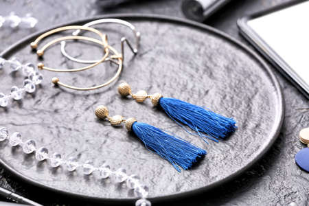 Plate with blue earrings and bracelets on dark backgroundの写真素材