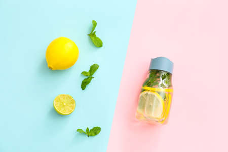 Bottle of clean water with lemon and mint on color backgroundの写真素材