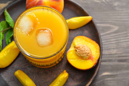 Glass of fresh peach juice on tableの写真素材
