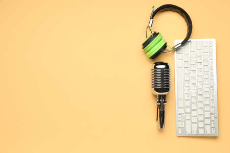 Headphones with microphone and computer keyboard on color backgroundの写真素材