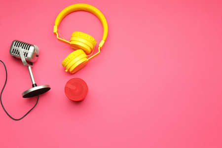 Headphones with microphone and speaker on color background