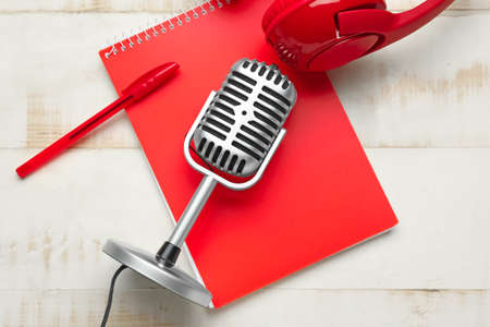Headphones with microphone and notebook on white wooden backgroundの写真素材