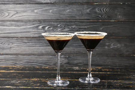Two glasses of tasty espresso martini cocktail on wooden backgroundの写真素材