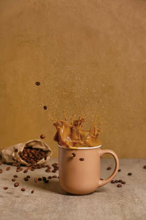 Cup of hot coffee with splash on table