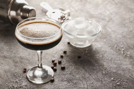 Glass of tasty espresso martini cocktail on grunge backgroundの写真素材