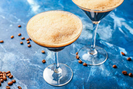 Glasses of tasty espresso martini cocktail on color backgroundの写真素材