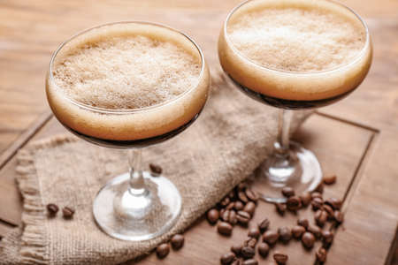 Two glasses of tasty espresso martini cocktail on wooden boardの写真素材