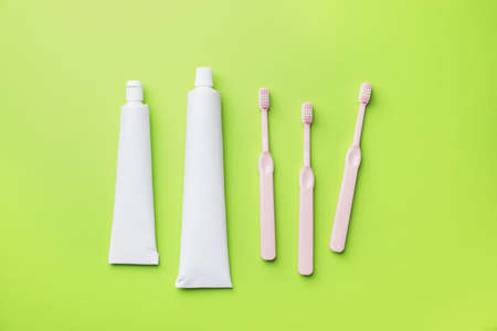 Toothbrushes and paste on color background