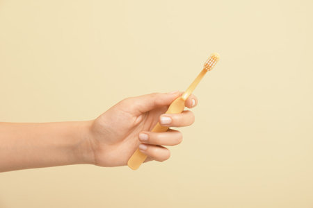 Female hand with toothbrush on color backgroundの写真素材