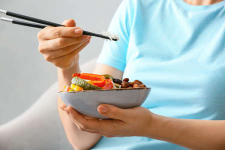 Woman eating rice salad with vegetables