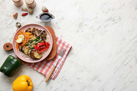 Plate of delicious rice salad with vegetables on light backgroundの写真素材