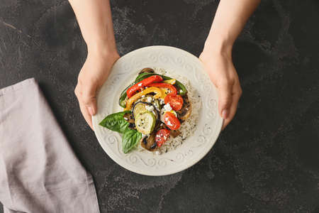 Woman with rice salad on dark backgroundの写真素材