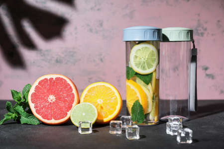 Bottles of infused water and citruses on tableの写真素材