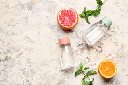 Bottles of water and citruses on light backgroundの写真素材