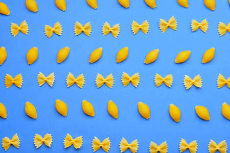 Tasty uncooked pasta on color backgroundの写真素材
