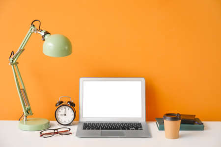 Stylish workplace with laptop near color wallの写真素材