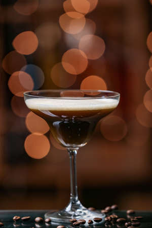 Glass of tasty espresso martini on blurred background