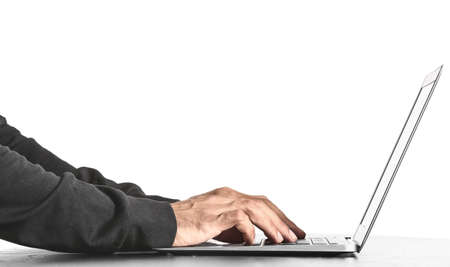 Professional hacker using laptop at table against white background