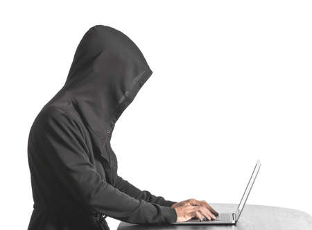 Professional hacker using laptop at table against white background