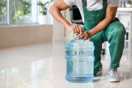 Delivery man with bottle of water in office