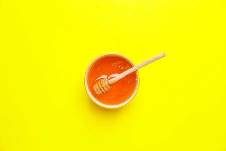 Bowl with honey on color backgroundの写真素材