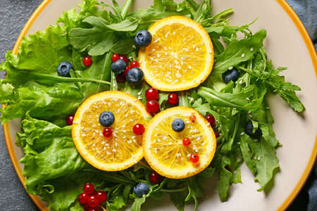 Plate with tasty arugula salad on dark background, closeupの写真素材