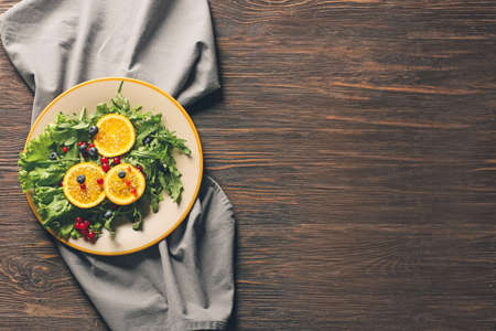 Plate with tasty arugula salad on wooden tableの写真素材