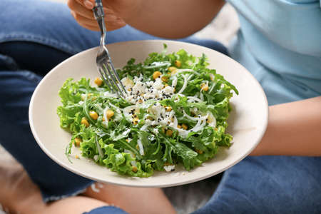 Woman eating tasty arugula salad, closeupの写真素材