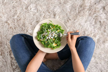 Woman eating tasty arugula salad, closeupの写真素材
