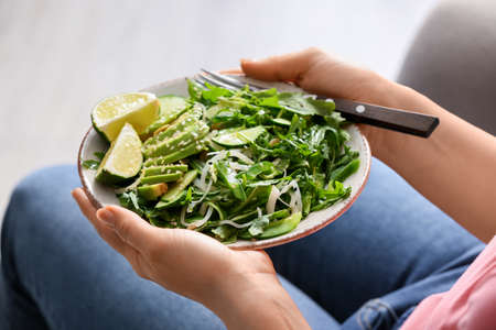 Woman holding plate with tasty arugula salad, closeupの写真素材