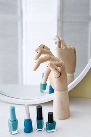 Wooden hand with nail polishes near mirrorの写真素材