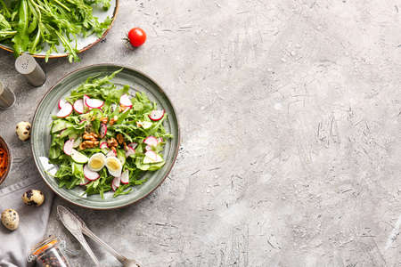 Plate with tasty arugula salad on dark backgroundの写真素材