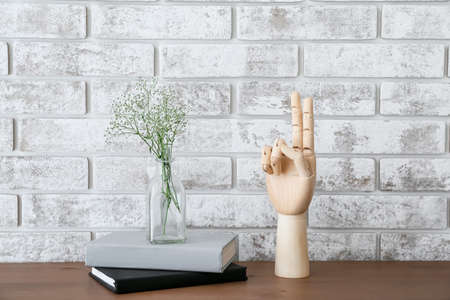 Wooden hand showing bless gesture on tableの写真素材