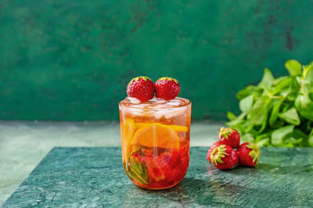 Glass of tasty strawberry mojito on color backgroundの写真素材