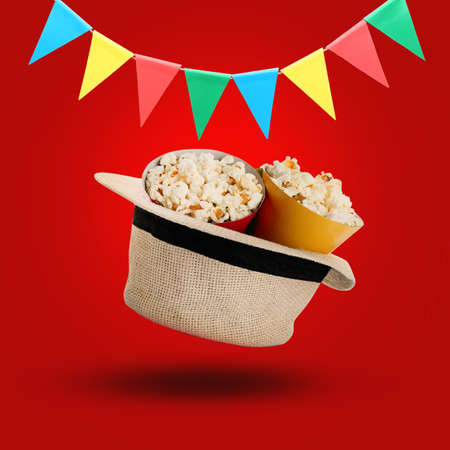 Flying farmer's hat with popcorn on color backgroundの写真素材