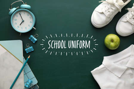 Stylish school uniform with stationery and alarm clock on color backgroundの写真素材