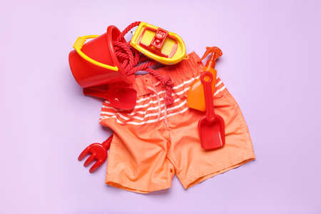 Set of beach accessories for children on color background