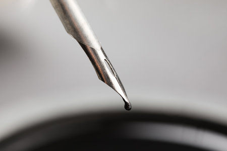 Black ink drop from nib pen on blurred backgroundの写真素材